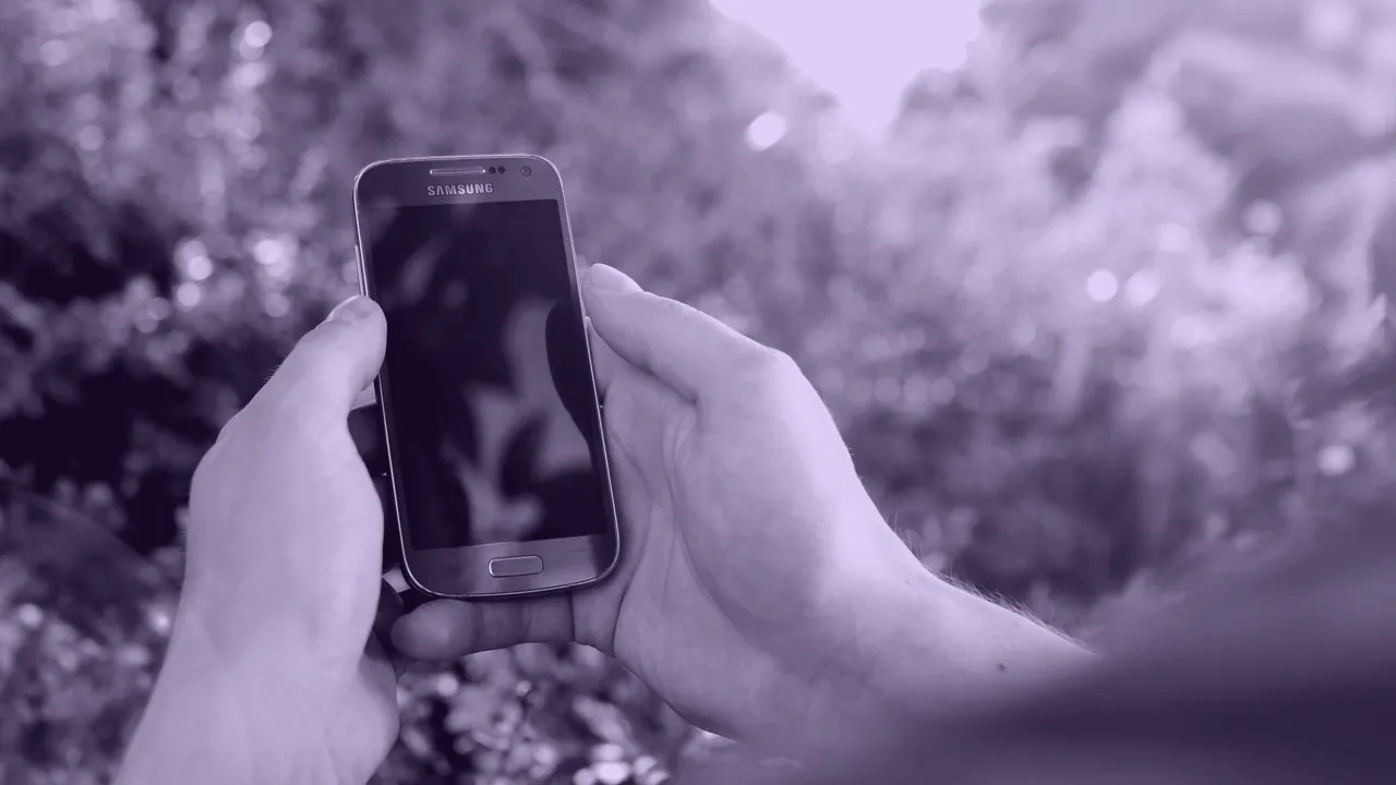 An Android handset held up outdoors.