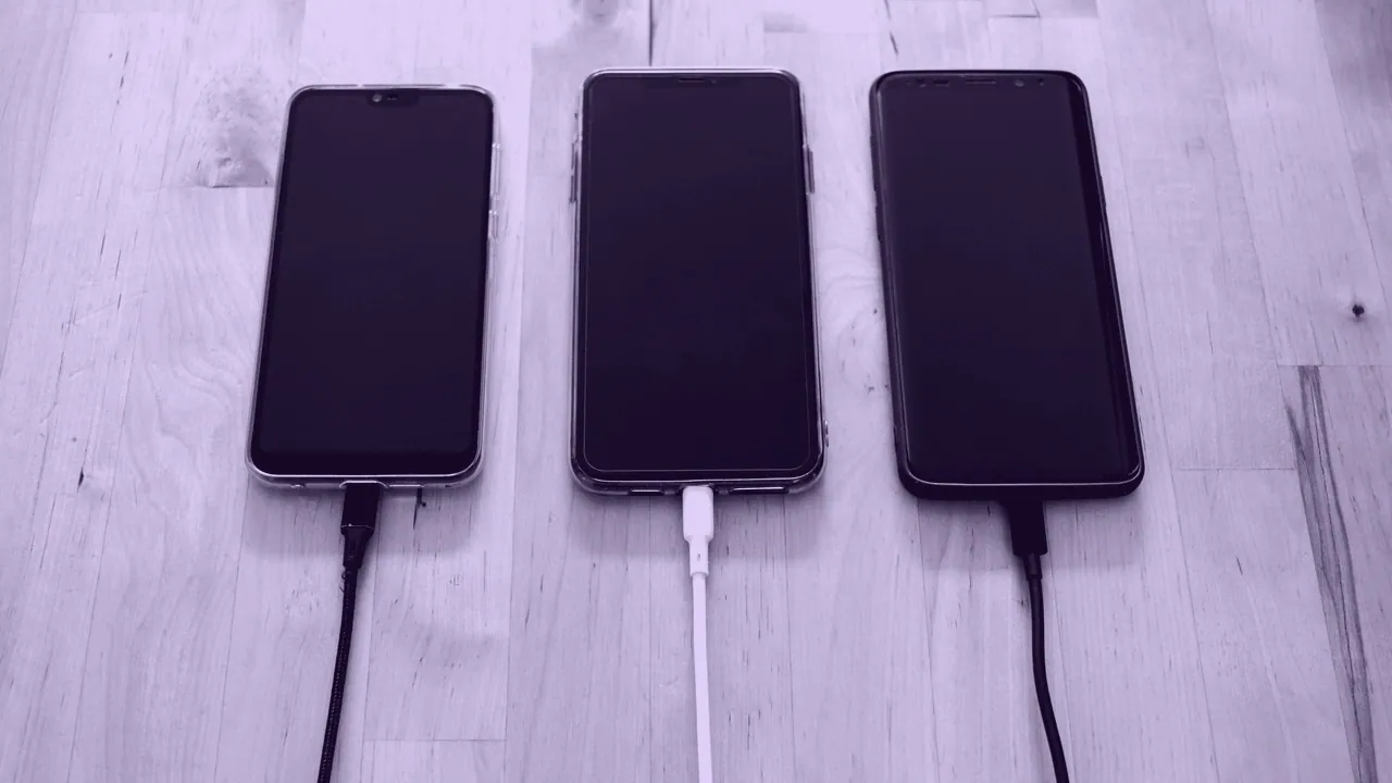 A phone on charge, cable attached.